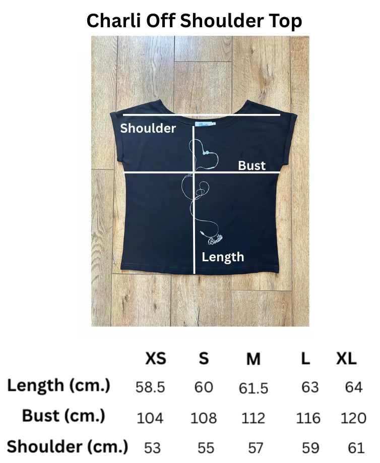 Black off-shoulder top with measurement chart on a wooden floor