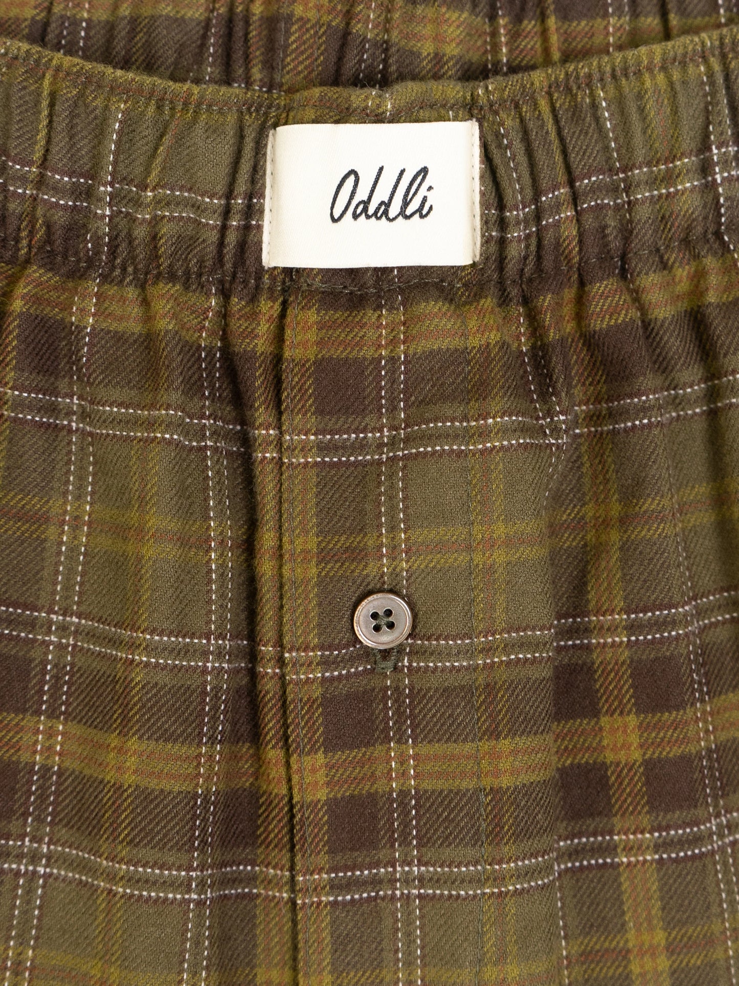 Plaid pants with a visible Oddli label