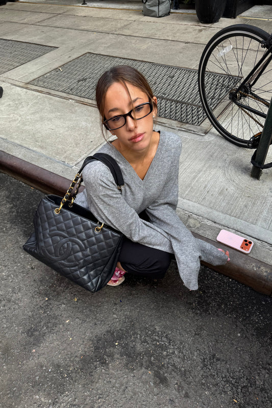 girl wearing a grey fine knit v-neck sweater in black and black capris with kitten heels and a chanel bag