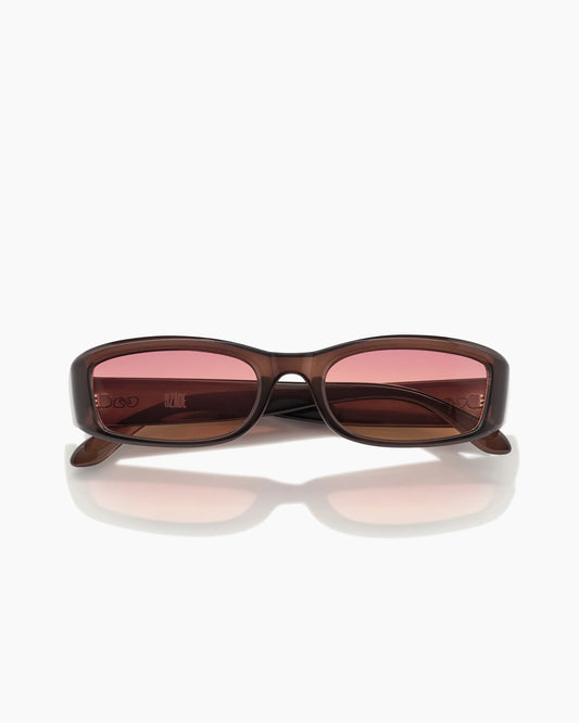 Sunglasses with brown frame and pink-tinted lenses on a white background