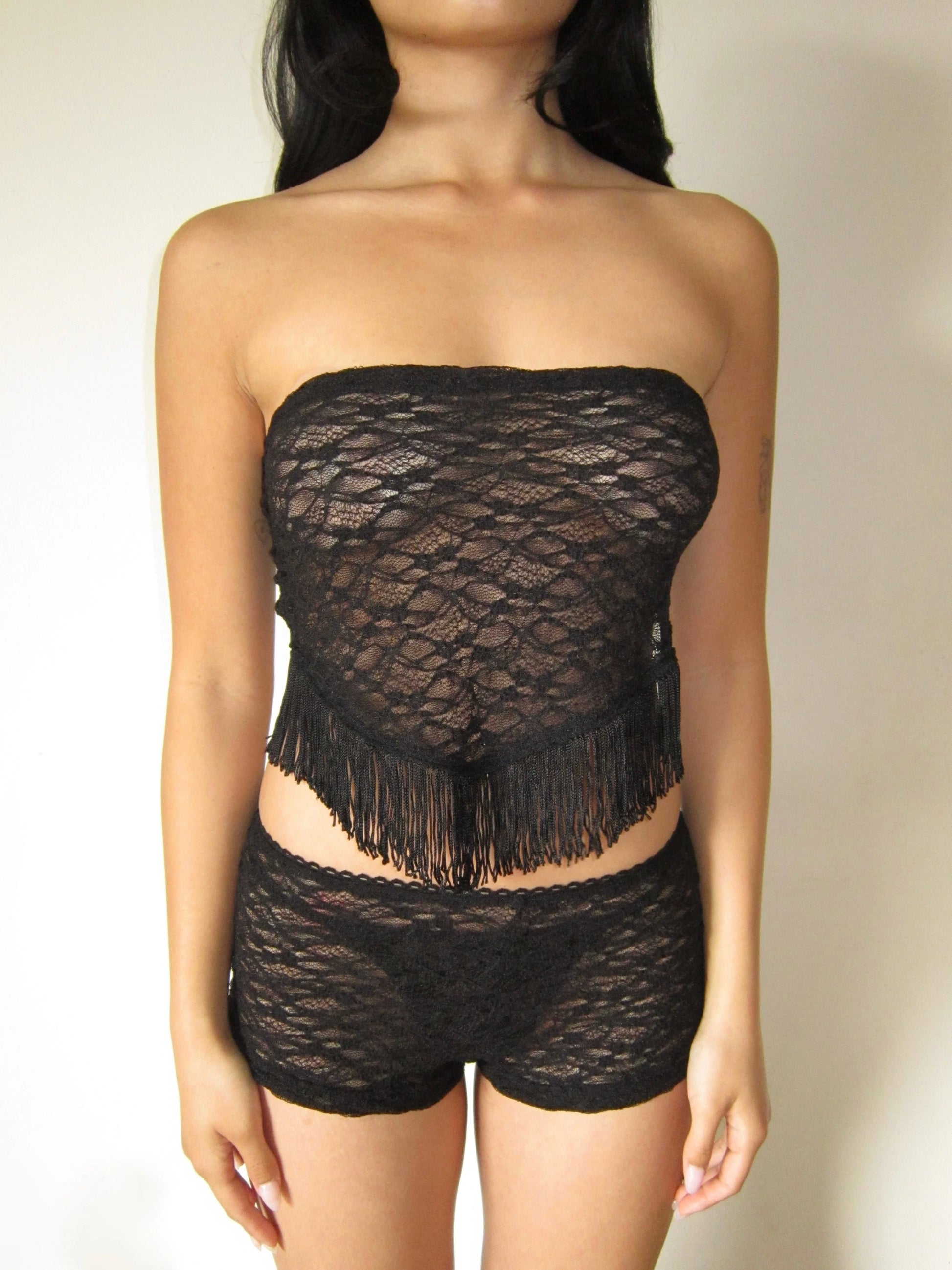 Black lace frill strapless top and shorts set on a neutral background