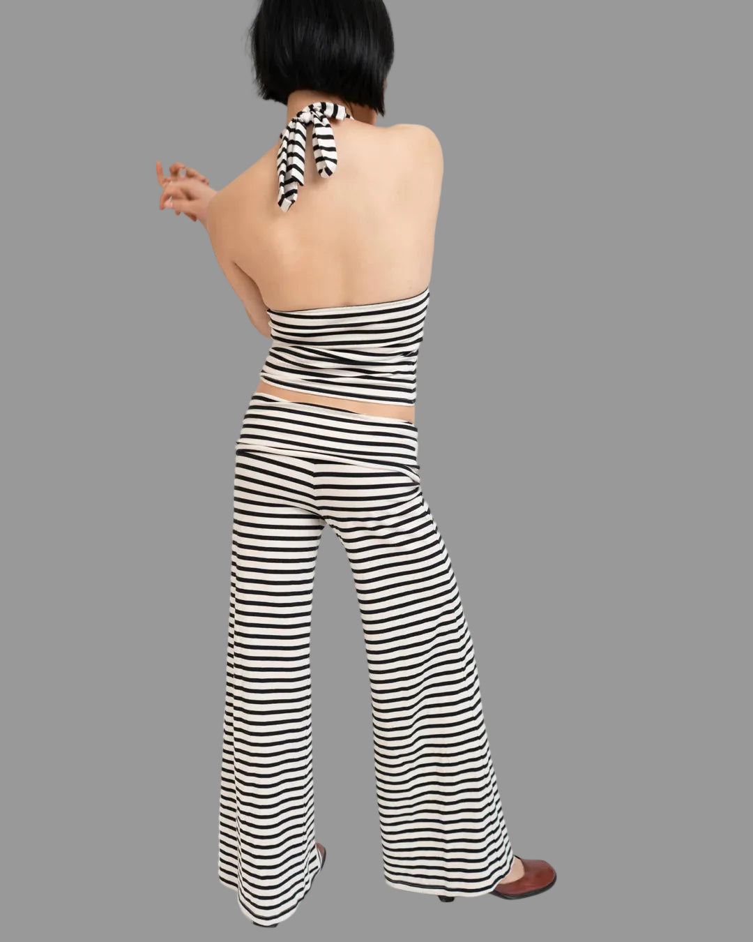 Woman wearing a black and white striped outfit on a white background