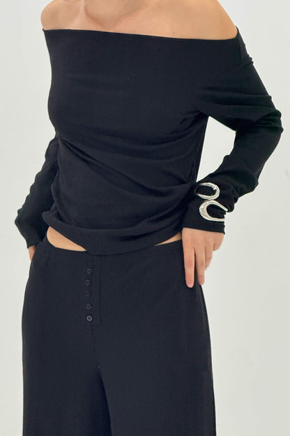 Black off-shoulder top and skirt set on a plain background
