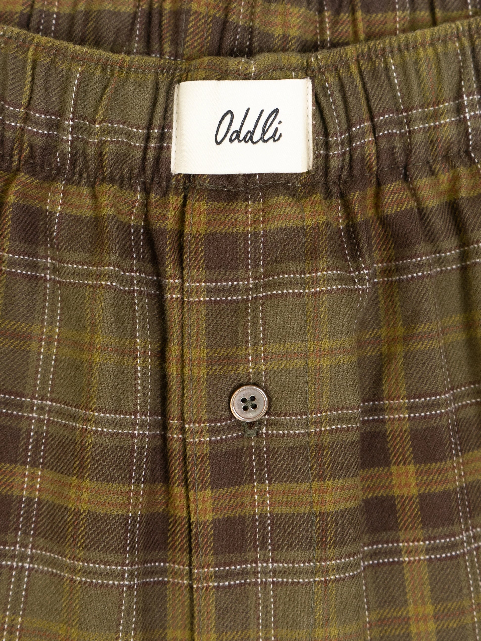 Plaid pants with a visible Oddli label