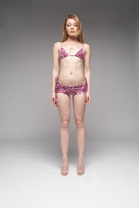 Woman wearing a pink bikini set on a gray background