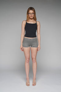 This image features a model showcasing the Brandy Cami in black, a soft and stretchy tank top made from organic cotton. The cami, defined by its minimalist design and delicate black color, emphasizes comfort and style.