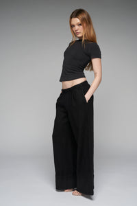 This image features the "Charlotte Pant" in black, showcasing a stylish and comfortable wide-leg design. The pants are made from 100% linen, which has been washed and pre-shrunk to ensure durability and a smooth fit.