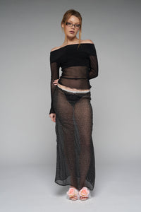This image features a stylish, long-sleeve sheer off-the-shoulder top creating a blend of elegance and casual chic