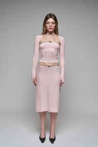 model wearing a midi slip skirt with a satin bow at the waist, in a pedal/onyx color, paired with a matching top.