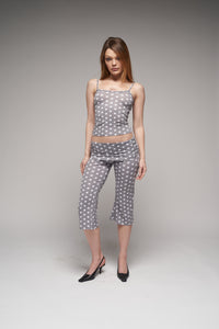 This image features a stylish gray polka dot cami top, paired with matching capri pants, showcasing a chic and trendy look. The cami top is designed with a comfortable fit, complemented by a playful polka dot pattern that adds a touch of whimsy.