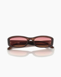 Sunglasses with brown frame and pink-tinted lenses on a white background